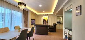 a living room with a dining room table and a living room at SWISS AVENUE HOTEL in Sungai Petani