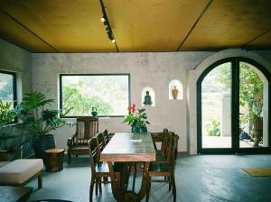 a dining room with a wooden table and chairs at Ananda Home in Tân Hiệp