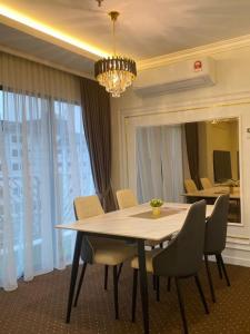 a dining room table with chairs and a chandelier at SWISS AVENUE HOTEL in Sungai Petani