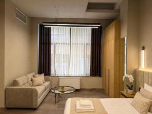 a living room with a couch and a large window at Yerevan Resident Hotel in Yerevan +32 photos