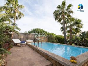 a swimming pool in a backyard with palm trees at Finca Mica in Llucmajor