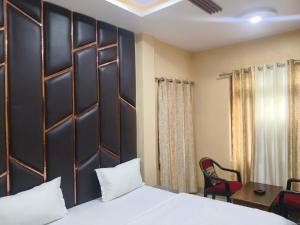 a bedroom with a bed and a desk and a chair at Hotel Avadh Balrampur in Balrāmpur