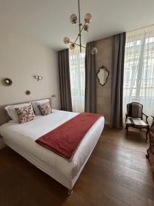 a bedroom with a large bed and a chandelier at La Maison Odeia Bordeaux Centre in Bordeaux +32 photos