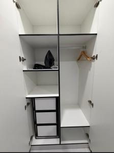 a walk in closet with white walls and glass doors at Doctors Apartment in Suva