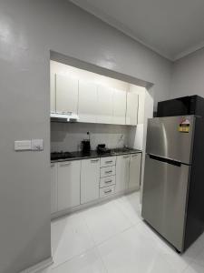 a kitchen with white cabinets and a stainless steel refrigerator at Doctors Apartment in Suva +20 photos