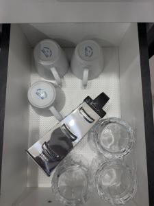 a white box with wine glasses and plates in it at Doctors Apartment in Suva