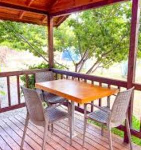 a wooden table and chairs on a porch at Fesleğenbükü Kamp in Çökertme