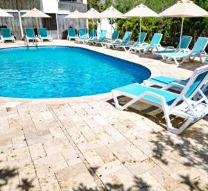 a swimming pool with lounge chairs and umbrellas at Fesleğenbükü Kamp in Çökertme