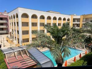 a hotel with a palm tree in front of a building at Rosa Virginia Apartment in Gallipoli