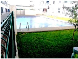 a swimming pool in a building with a fence at Apartamento Cala Busquets 6 pax in Ciutadella