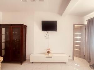 Ein Wohnzimmer mit einem Fernseher an einer weißen Wand in der Unterkunft Hotel Etrusco in Gherla