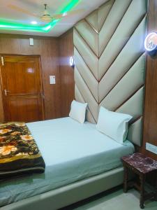 a bedroom with a bed with a wooden headboard at Hotel Avadh Balrampur in Balrāmpur +18 photos