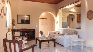 a living room with a couch and a table at Ocean Breeze Apartment - Panoramic Sea View & Olive Grove - 100m to Beach in Kypseli