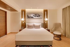 a bedroom with a white bed and a chair at Lemon Tree Premier, Biratnagar, Nepal in Biratnagar +46 photos