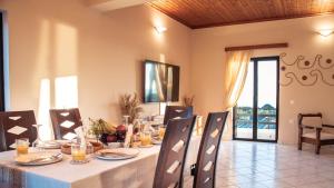 a dining room with a table and chairs with a view at Ocean Breeze Apartment - Panoramic Sea View & Olive Grove - 100m to Beach in Kypseli