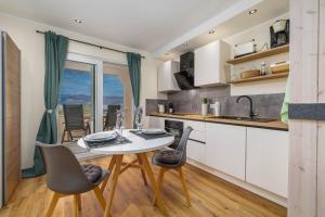 a kitchen and dining room with a table and chairs at Seaview apartments Refugium Krk in Polje +33 photos