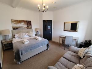 a bedroom with a bed and a couch at The Downe Arms Inn in Castleton