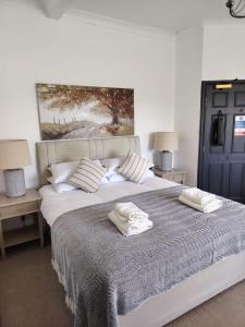 a bedroom with a large bed with two towels on it at The Downe Arms Inn in Castleton