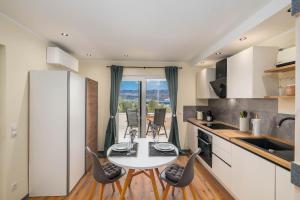 a kitchen with a table and chairs in a kitchen at Seaview apartments Refugium Krk in Polje