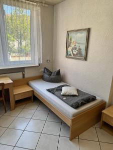 ein Bett in einem Zimmer mit einem Tisch und einem Fenster in der Unterkunft Hotel Fantastic in Neckartenzlingen