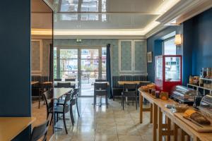 a restaurant with blue walls and tables and chairs at Hotel AMERIQUE in Palavas-les-Flots