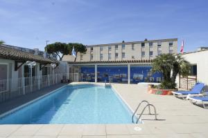 a swimming pool in front of a hotel at Hotel AMERIQUE in Palavas-les-Flots