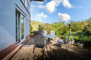 a patio with chairs and a table and a window at Ferienwohnung Gartengeschoss in Durbach