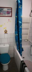 a bathroom with a toilet and a blue shower curtain at Kawalerka in Gdynia