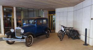 an old blue car parked in a building with bikes at INX Design Hotel in Krakow