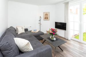 a living room with a gray couch and a table at Ant Diekskant in Juist