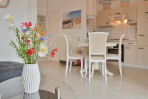 a vase with flowers on a glass table in a living room at Bungalow Nebel Nr 3 in Kellenhusen