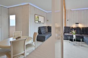 a living room with a table and a couch at Bungalow Nebel Nr 3 in Kellenhusen