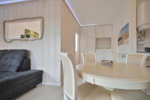 a dining room with a table and a couch at Bungalow Nebel Nr 3 in Kellenhusen