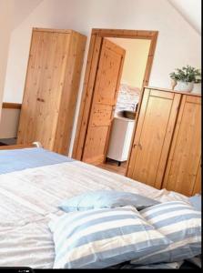 a bedroom with a bed and wooden walls and a door at Nicht Daheim und doch Zuhaus in Heiligenhafen