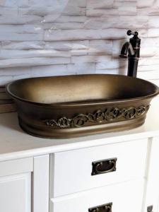 a copper sink on top of a white cabinet at Nicht Daheim und doch Zuhaus in Heiligenhafen