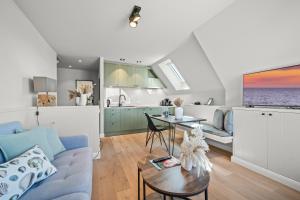 a living room with a blue couch and a table at Traumloft Wenningstedt in Wenningstedt
