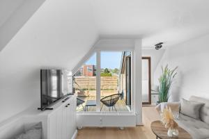 a living room with a couch and a tv at Traumloft Wenningstedt in Wenningstedt