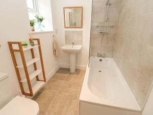 a bathroom with a tub and a sink and a toilet at Dairy Cottage in Kirkby Stephen +30 photos