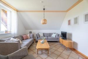 a living room with a couch and a tv at Ferienwohnung im Obergeschoss in Durbach