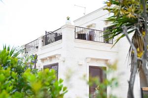 a white building with a balcony on top of it at Casa Macchiosa in Torre Canne +122 photos