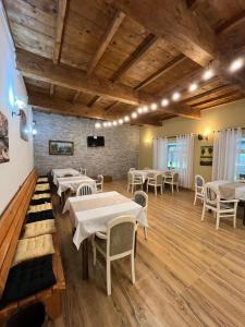 a dining room with tables and chairs and a stone wall at prekal park kamping in Shkodër