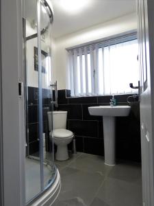 een badkamer met een toilet, een wastafel en een douche bij StayNEC Moat House Birmingham - For Company, Contractor and Leisure Stays - NEC, HS2, JLR, Airport in Birmingham