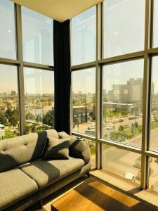 a living room with a couch in front of a large window at Koll Hotel in Erbil
