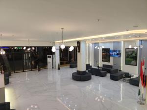 a lobby with couches and tables in a building at Koll Hotel in Erbil