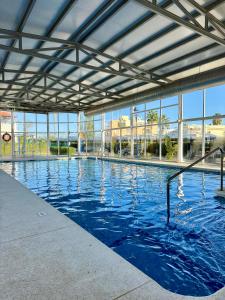 a large swimming pool with blue water in a building at El Mirador de Torremari - Nudista - Vera playa in Vera