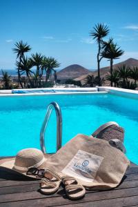 a pair of sandals and a towel next to a swimming pool at Villa El Erizo - Pool By Lanzarote Vacation Homes in Nazaret