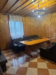 a living room with a wooden table and leather furniture at Садиба Близнюки in Vorokhta +92 photos