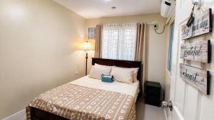 a small bedroom with a bed and a window at J&J Antipolo Place 2BR with Netflix & Karaoke in Antipolo