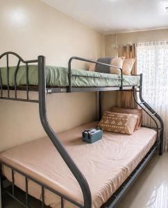 two bunk beds in a room with a suitcase at J&J Antipolo Place 2BR with Netflix & Karaoke in Antipolo