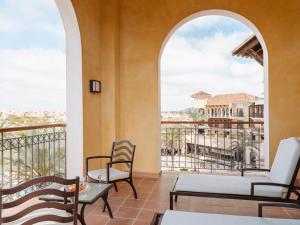 a room with a balcony with two chairs and a table at Ona Mar Menor Golf & Spa in Torre-Pacheco